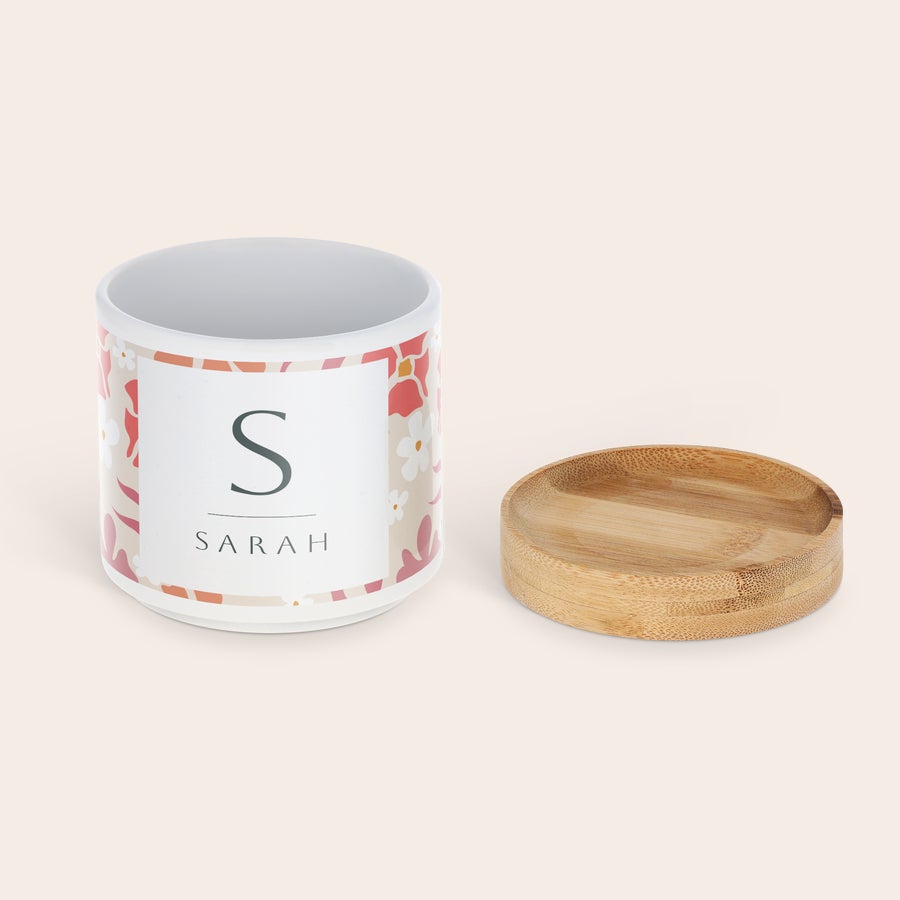Personalised flower pot White ceramic personalized flower pot printed with Sarah's name and initial, next to a bamboo coaster, for greenery.