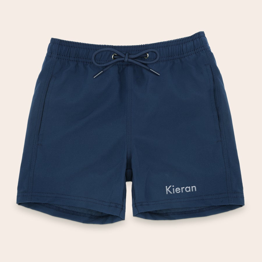 Calções de banho personalizados Shorts de banho azul marinho com cordão, bordado com o nome "Kieran" em branco. Arrase com shorts de banho bordados.