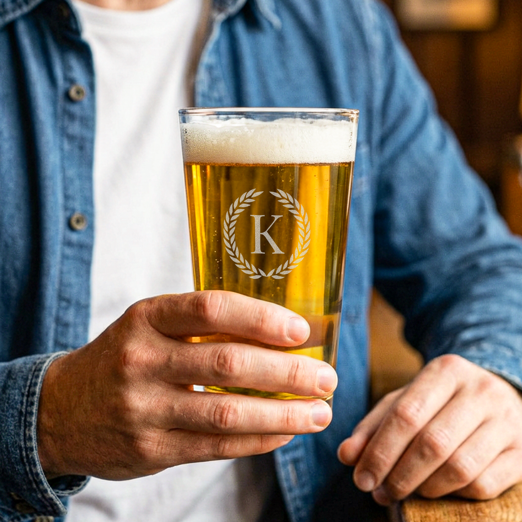 Gravert ølglass med personlig initial “K” og laurbærkrans.