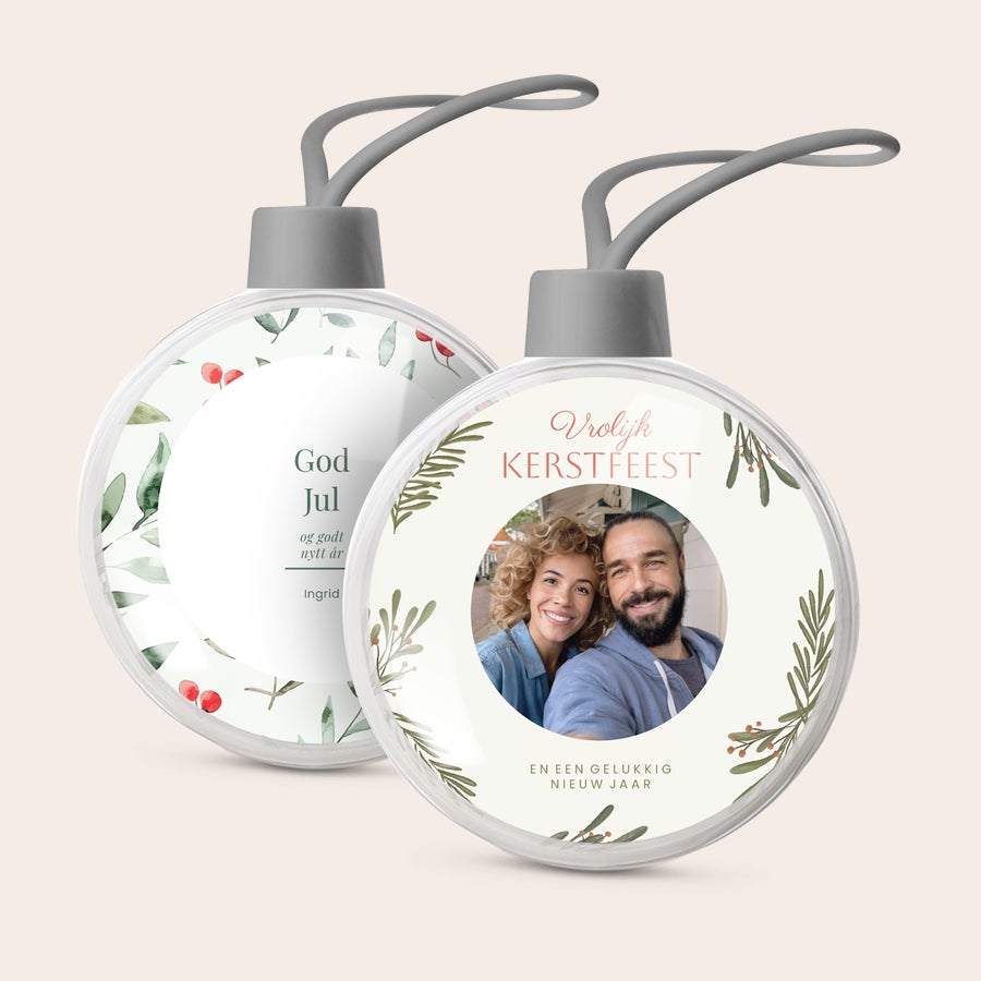 Gepersonaliseerde kerstbal Twee transparante gepersonaliseerde kerstballen met eigen foto en kersttekst, gedrukt met kerstmotieven.