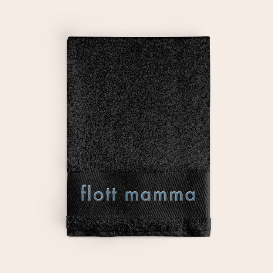 Håndkle med tekst Svart brodert håndkle med navnet "flott mamma" brodert i blå tråd