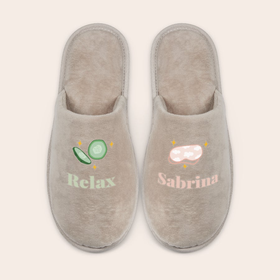 Personlige hjemmesko Bløde beige hjemmesko, hvor den ene er trykt med ordet Relax, agurkeskiver, og den anden med navnet Sabrina, øjenmaske