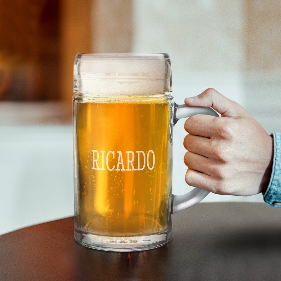 Graverat 1L ölglas Hand håller ett personligt 1L ölglas fyllt med öl, graverat med namnet Ricardo. Skål för det goda livet!