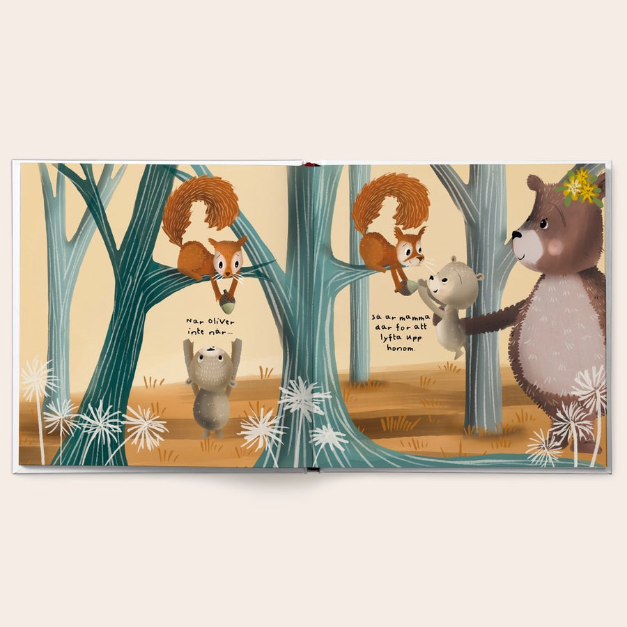 Personlig bok - Mamma i din kärleksfulla famn Personlig “Mamma i din kärleksfulla famn”-bok öppen, med en tecknad mamma björn som sträcker ut armen för att hjälpa en mindre björn. Boken innehåller anpassade textinslag som