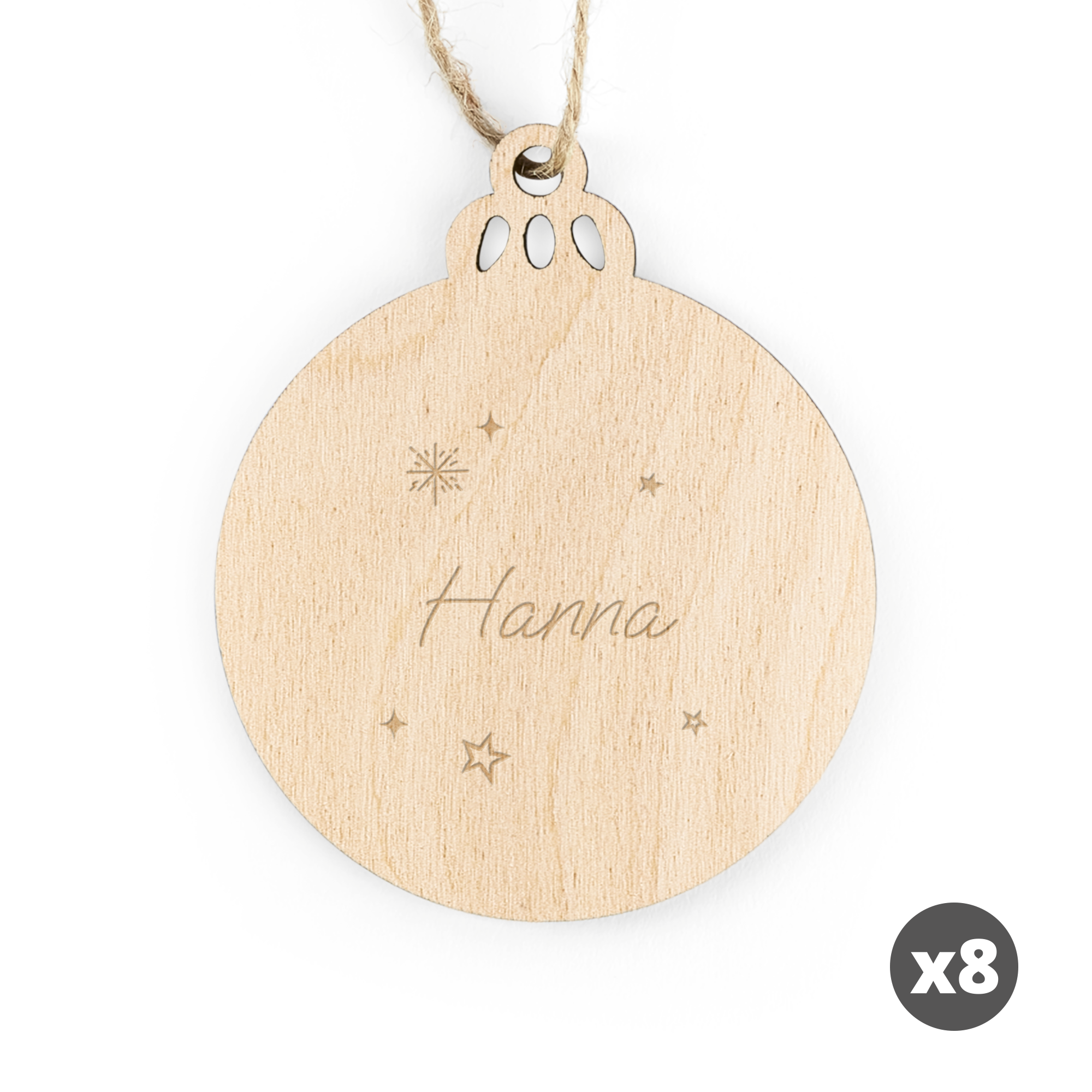 Graverad juldekoration i trä, rund form med snöre, texten "Hanna" och stjärnor