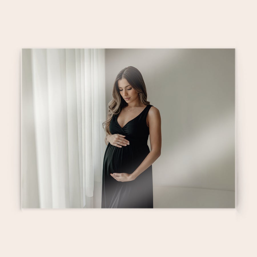 Fotografie pe acrilic Fotografie acrilică personalizată, cu o femeie însărcinată în rochie neagră, mângâindu-și burtica, imprimată direct pe acrilic.
