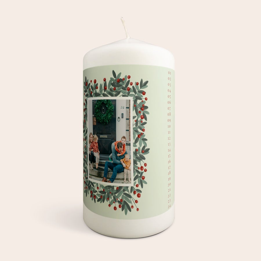 Vianočné adventné sviečky Personalizovaná adventná sviečka s fotografiou rodiny a menom, ozdobená vianočným vencom a číslami 1-24.