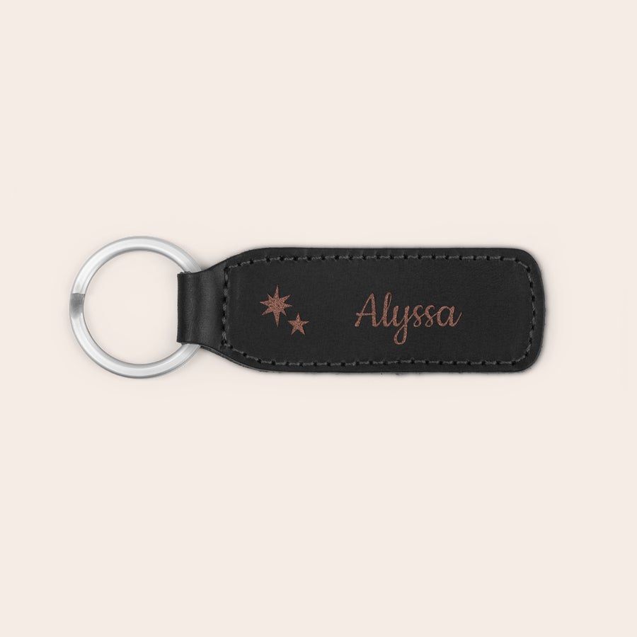 Llaveros de cuero Llavero personalizado de cuero negro con anilla metálica, grabado con el nombre Alyssa y dos estrellas.