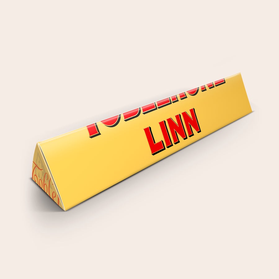 Toblerone med namn En personaliserad Toblerone med egen texten LINN tryckt i rött på gul förpackning