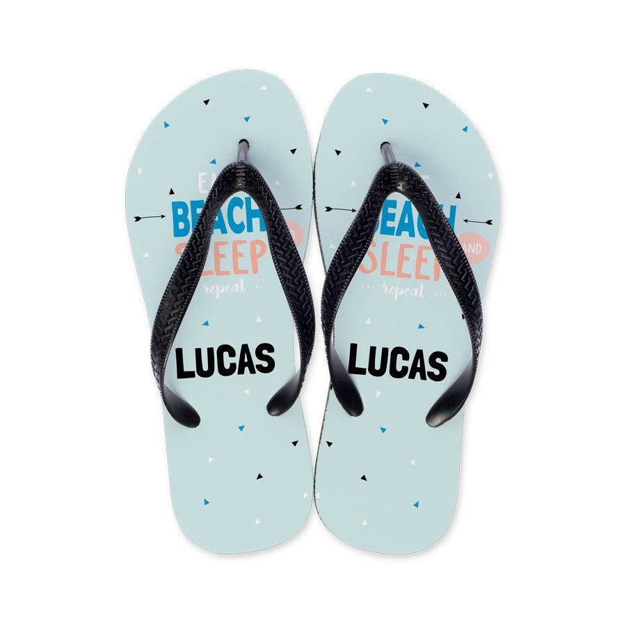 Individuelle Zehensandalen in Hellblau mit Namen Lucas, "Eat Beach Sleep Repeat" und kleinen Dreiecken als Sommerhit bedruckt
