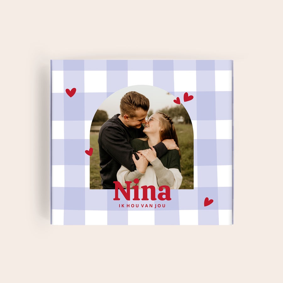 Milka Pralines Love Milka giftbox met foto van een koppel en de gepersonaliseerde tekst Nina Ik hou van jou, geprint op een paars-wit geruit patroon.