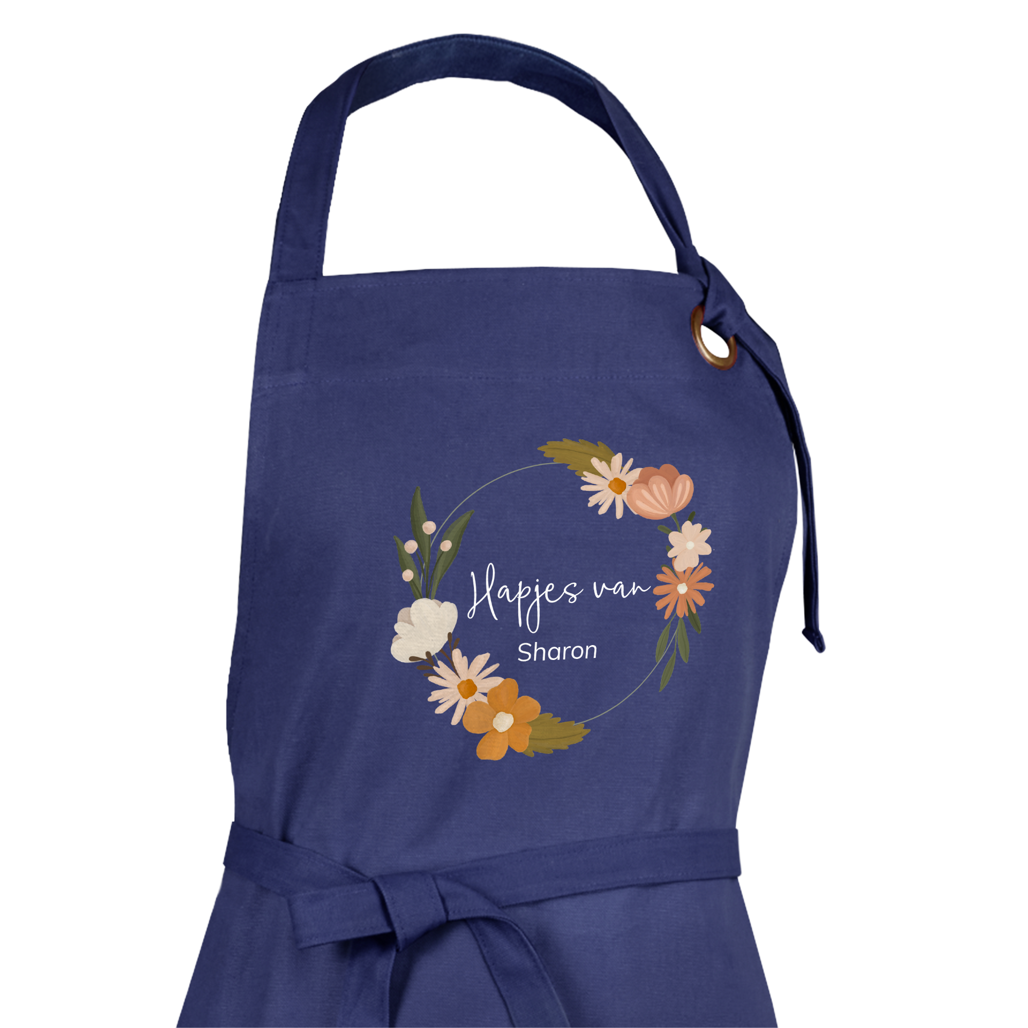 Een donkerblauw gepersonaliseerd keukenschort met de tekst "Hapjes van Sharon" gedrukt in een bloemenkrans.