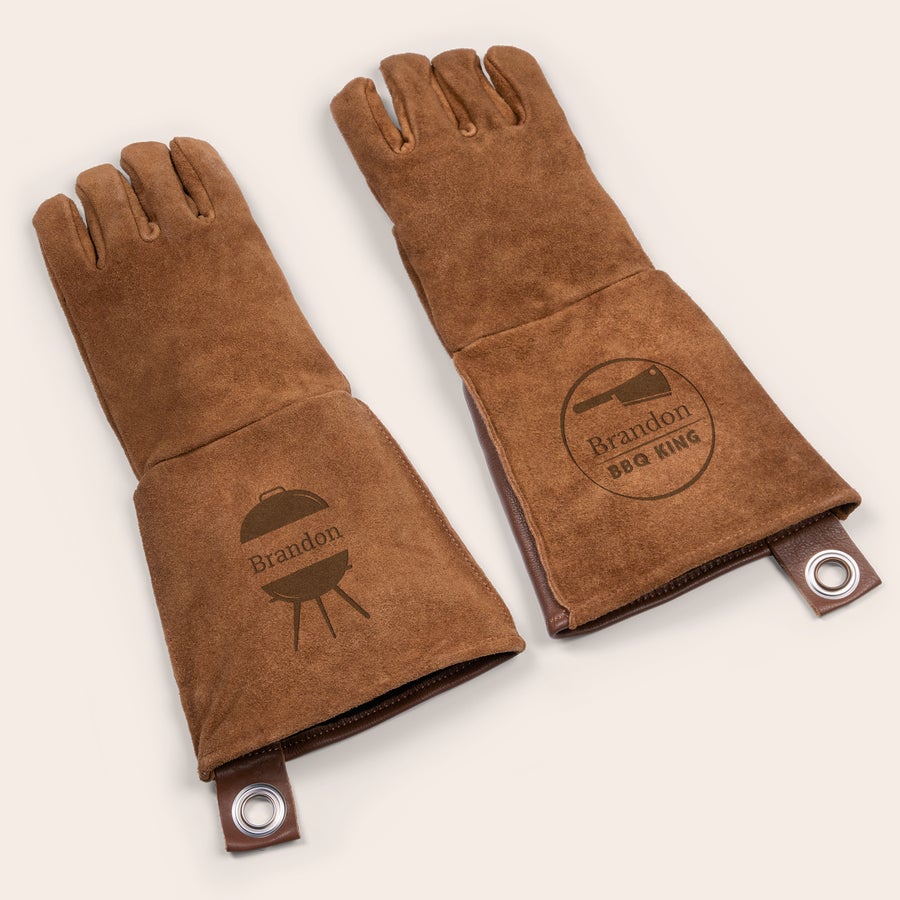 Mănuși de grătar personalizate din piele Set mănuși de grătar din piele maro, personalizate cu numele Brandon gravat și un logo BBQ pe fiecare mănușă. Nicio rețetă nu este prea dificil de realizat cu un set de mănuși de grătar din piele gravate.