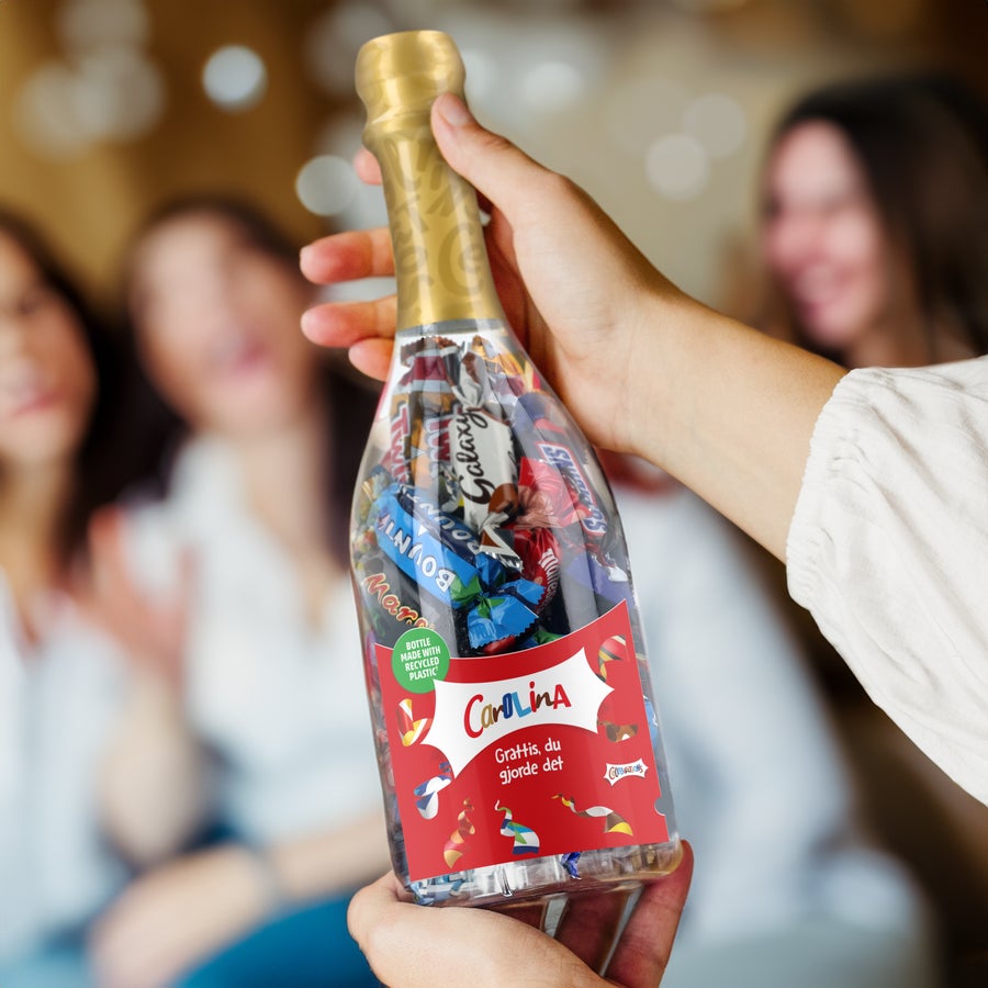 Personlig Celebrations gåva Champagneflaska fylld med Celebrations-choklad. Etiketten är anpassad med texten "Carolina Grattis, du gjorde det", vem vill du fira med denna Celebrations-champagneflaska?