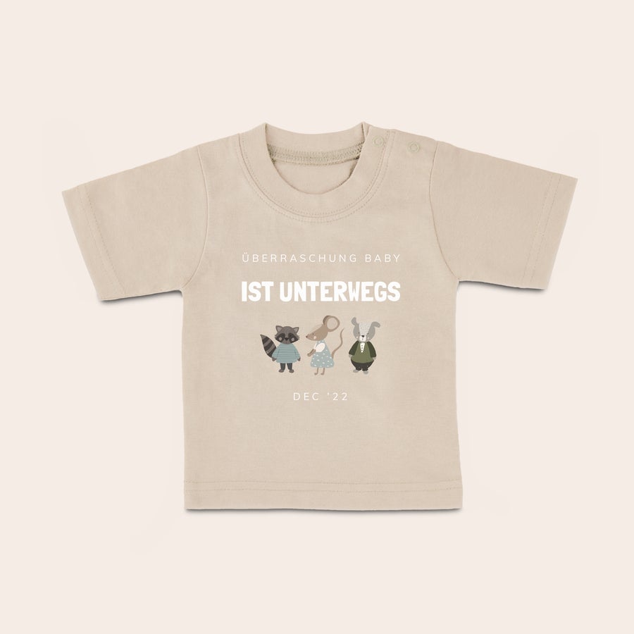 Baby t shirt bedrucken Beiges Baby T-Shirt mit Aufdruck "ÜBERRASCHUNG BABY IST UNTERWEGS", Tiermotiven und Datum DEC '22, bedruckt mit Ihrem Text