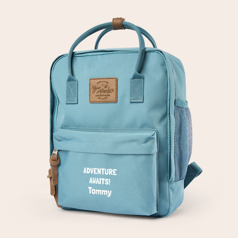 Personalised backpack - Children Light blue children's backpack with "Adventure Awaits! Tommy" printed on the front. This personalised children's backpack is ideal for school.