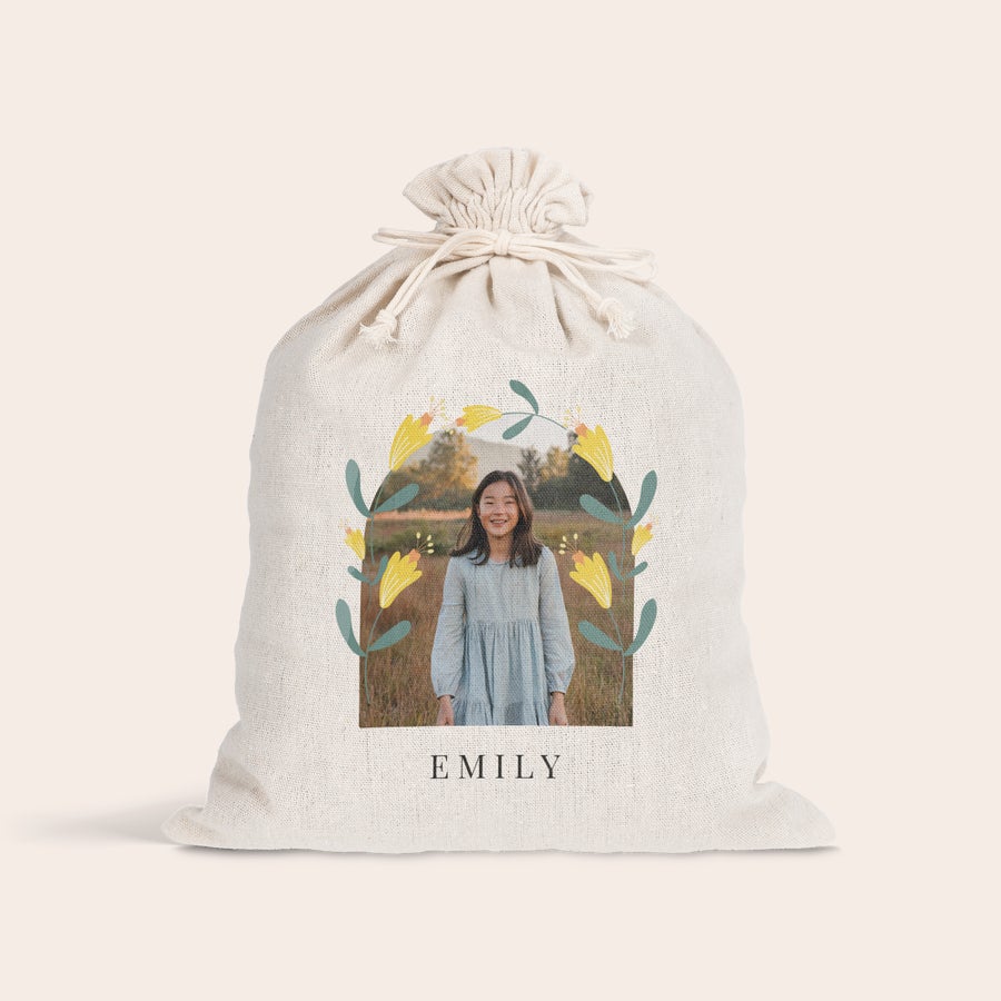 Presentpåse med dragsko - påsk Personlig presentpåse med dragsko, tryckt med en bild av en flicka omgiven av blommor och namnet Emily. Gör påsken speciell.