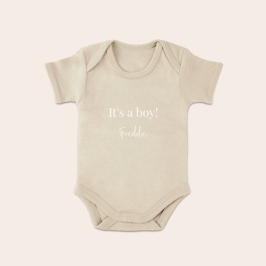 Detský romper Béžový detský overal s krátkym rukávom, potlačený textom It's a boy a menom Freddie, prekvapte nových rodičov roztomilým overalom s potlačou.
