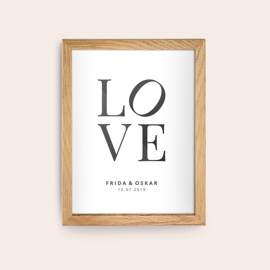 Innrammet bilde Personlig plakat i treramme med trykt teksten "LOVE" og navnene Frida & Oskar, dato 12.07.2019.