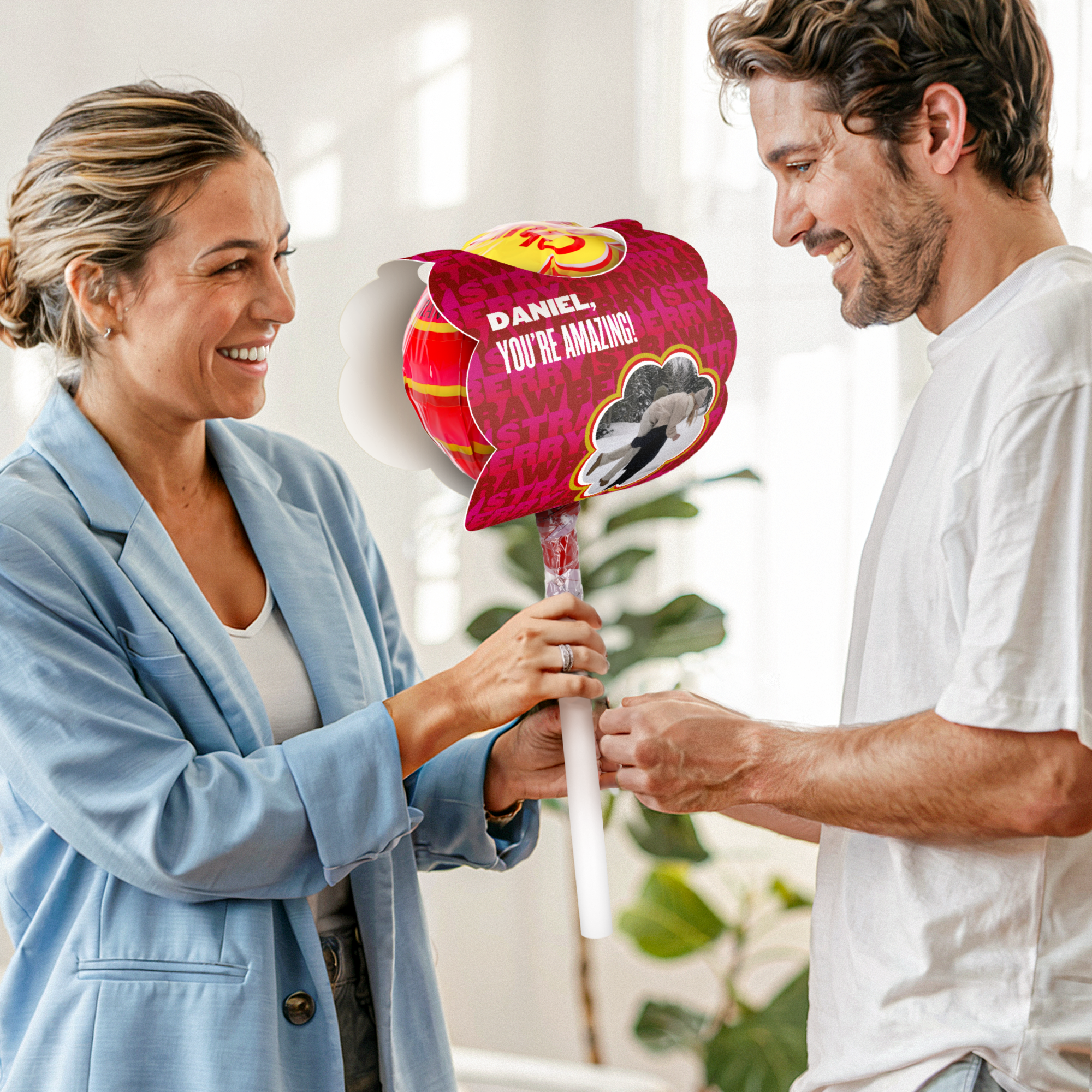 Mega Chupa Chups personalizado Morango 20 pirulitos com nome e foto impressos, oferecido a um homem sorridente.
