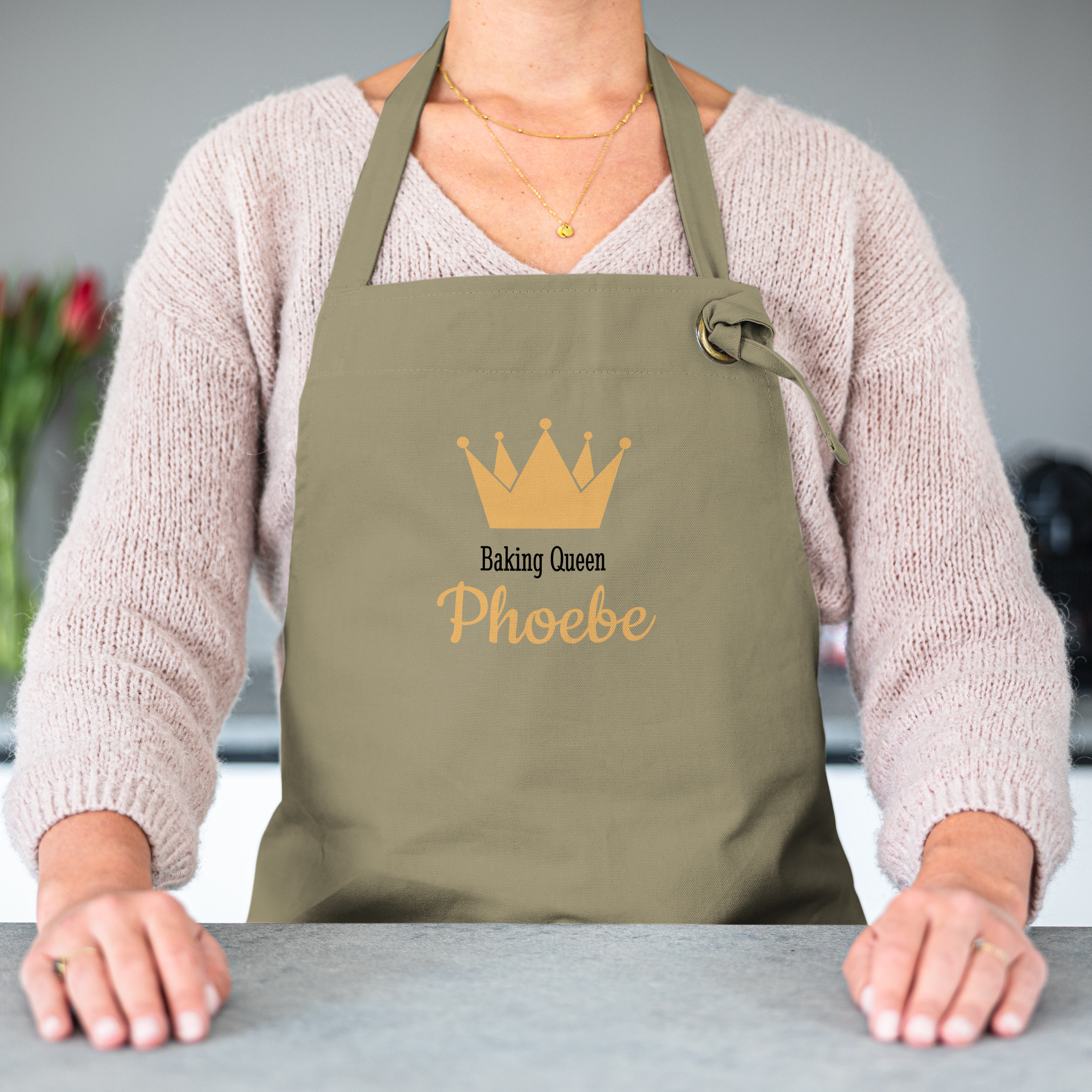Personaliziran predpasnik z natisnjenim napisom Baking Queen Phoebe in zlato krono