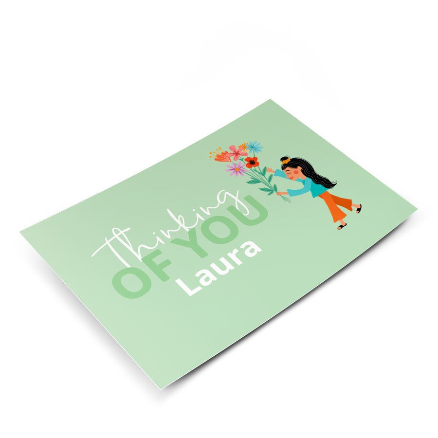 Um cartão personalizado para qualquer ocasião, impresso com "Thinking of You" e nome Laura com uma menina e flores.