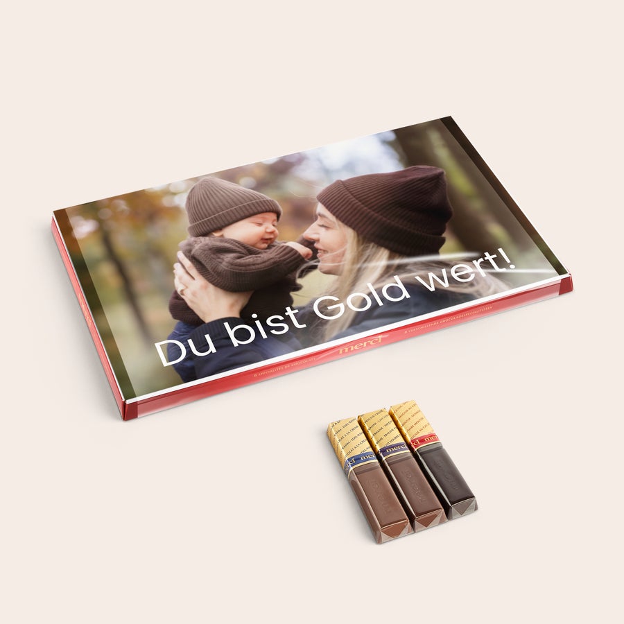 Personalisierte Merci Schokolade - Mit Grußkarte Merci Schokolade mit personalisierter Grußkarte 400 Gramm. Eine bedruckte Schachtel mit einem Foto von Mutter und Baby und dem Text Du bist Gold wert.