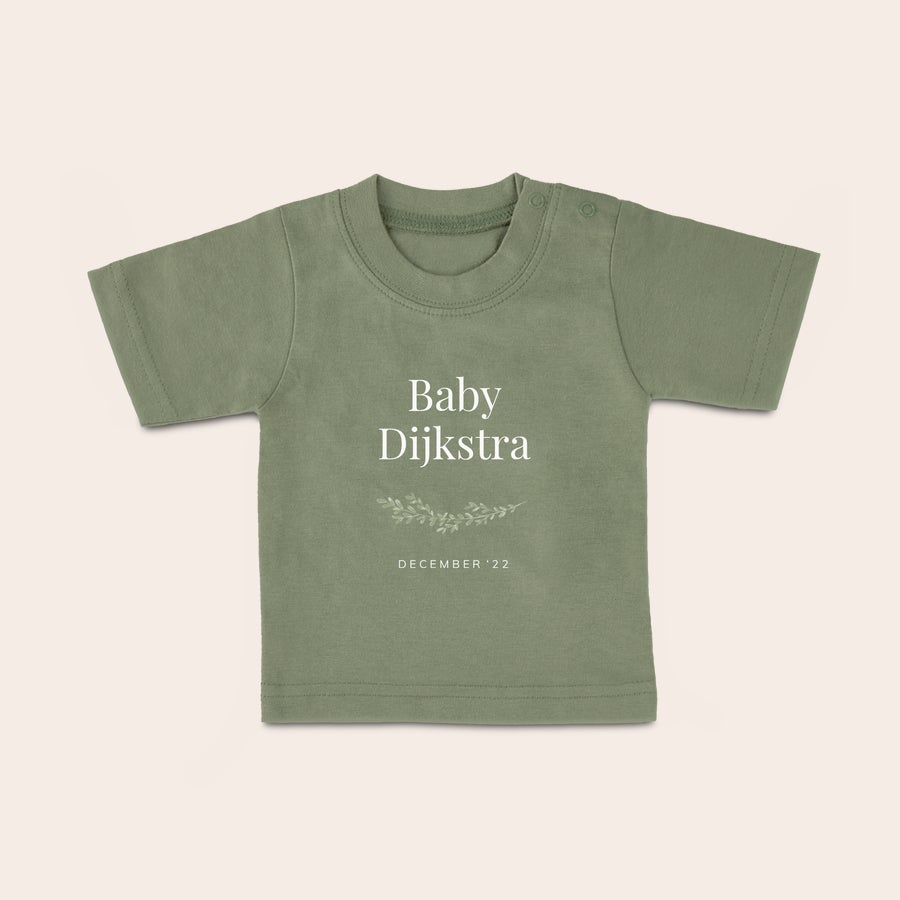 Baby shirt bedrukken Olijfgroen baby shirt met naam Baby Dijkstra en de datum December '22 geprint, versierd met takjes.