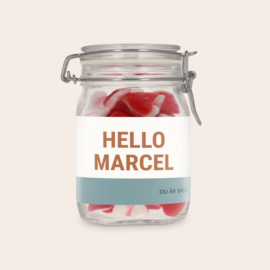 Personifierad godisburk Personlig sötburk med hjärtan fylld med godis. Etiketten är tryckt med texten "HELLO MARCEL" och "DU ÄR BÄST!".