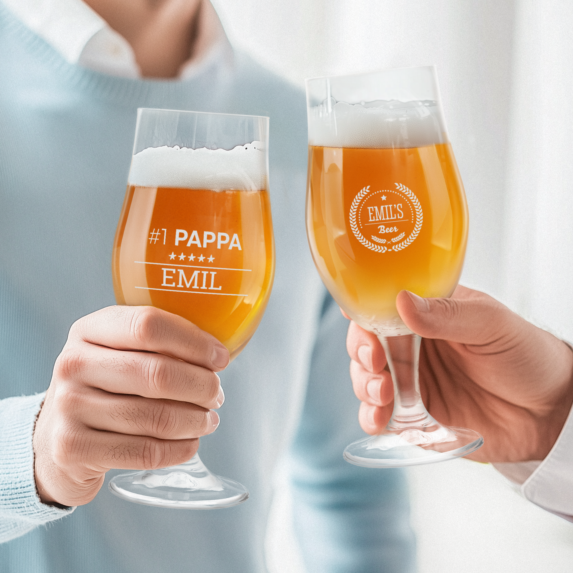 Två händer skålar med fyllda ölglas, graverade med Emil och Emils Beer motiv, för att överraska någon.