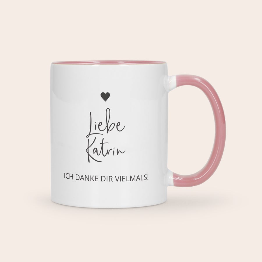 Farbige Tasse Bedrucken Weiße Tasse mit rosa Henkel, bedruckt mit dem Namen Katrin und dem Text "Ich danke dir vielmals!" sowie einem kleinen schwarzen Herz.