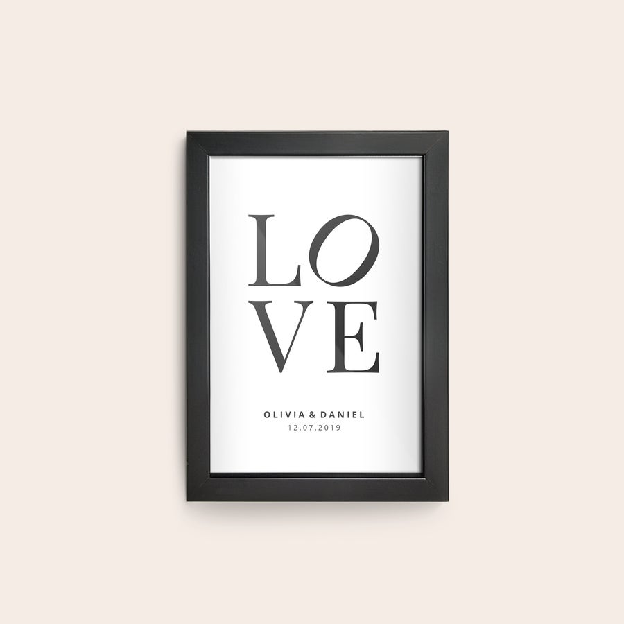 Kehystetty valokuva Musta kehys valkoisella pohjalla teksti LOVE ja alla nimet Olivia & Daniel sekä päivämäärä 12.07.2019. Luo kauneimmasta valokuvastasi juliste seinällesi.
