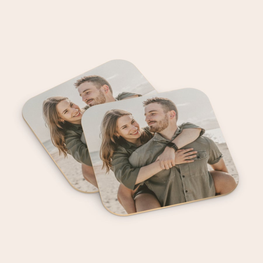 Personalizované pivní tácky Dva personalizované pivní tácky potištěné fotografií zamilovaného páru na pláži.