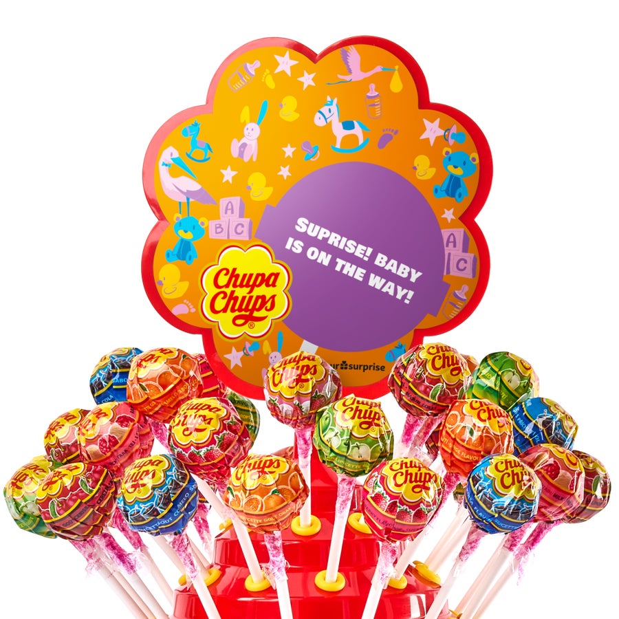 Turn de Chupa Chups personalizat, cu un mesaj imprimat "Surprise! Baby is on the way!" și decorațiuni pentru bebeluși.