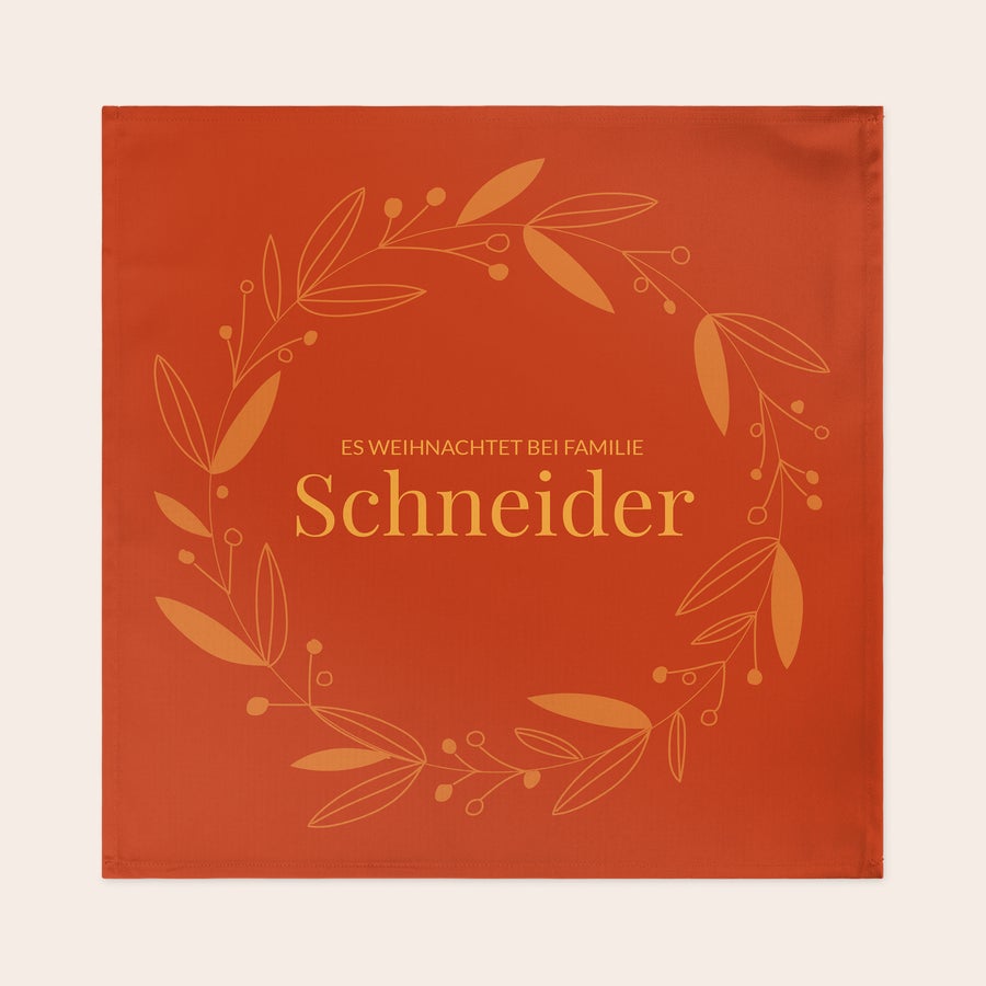 Servietten bedrucken Rote personalisierte Servietten mit Kranzdesign und der Aufschrift "Es weihnachtet bei Familie Schneider", bedruckt.