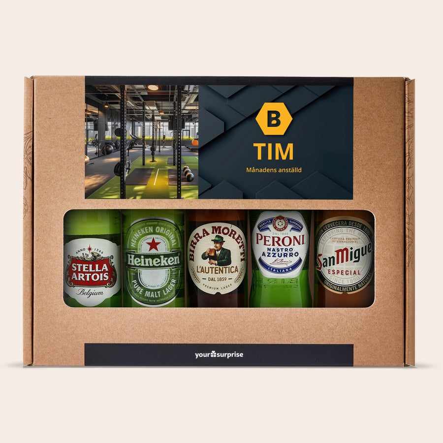 Personlig Ölpresent - Födelsedag Ölpaket med fem internationella öl. Lådan är tryckt med ett foto på ett gym och texten TIM Månadens anställd. skål!