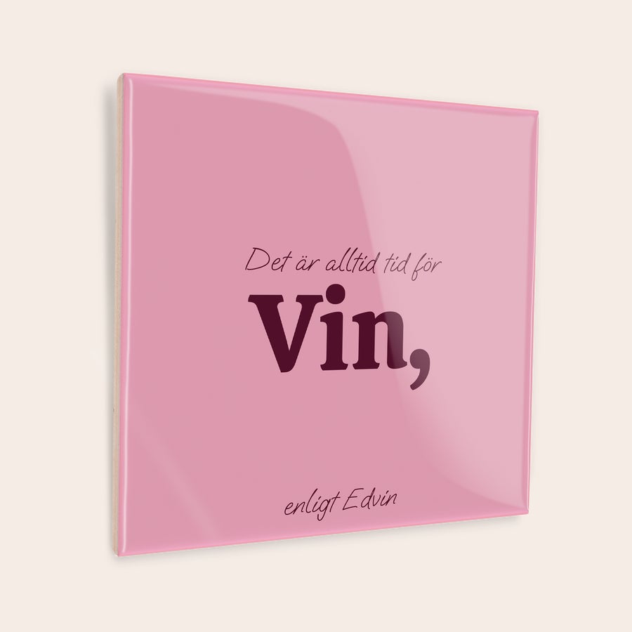 Ordspråkskakel Rosa kakelplatta med texten Det är alltid tid för Vin enligt Edvin tryckt på en personlig kakelplatta.