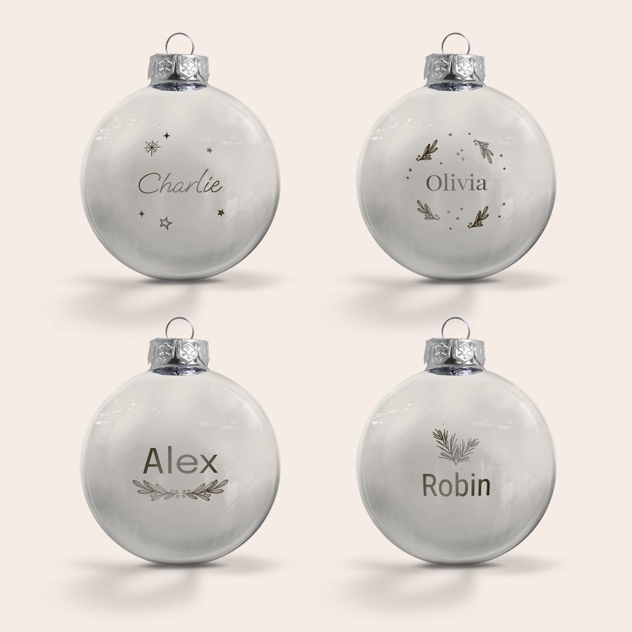 Glasjulkulor med namn Fyra vita julgranskulor av glas med silverfäste, graverade med namn som Charlie, Olivia, Alex och Robin, samt symboler. Ge din julgran en personlig touch.