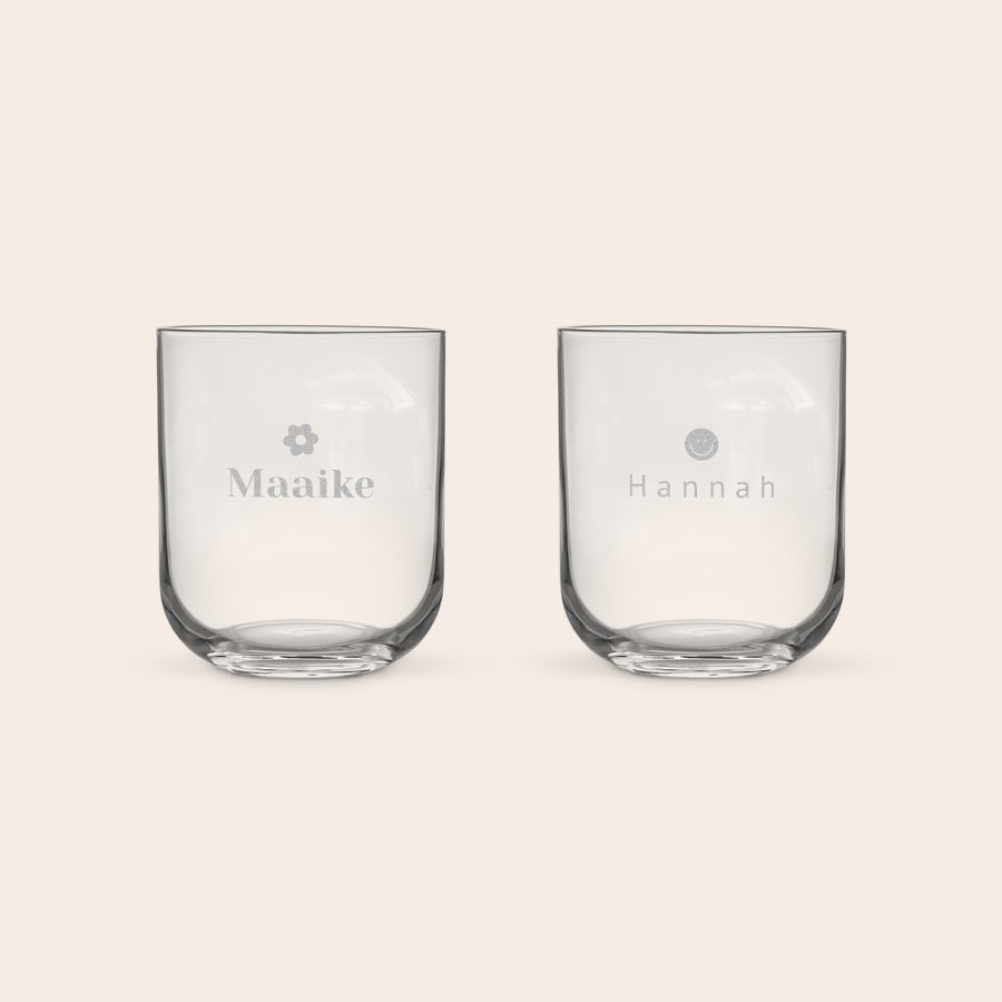 Waterglas graveren Twee waterglazen, gegraveerd met de namen Maaike en Hannah en een klein bloemetje en smiley. Een glaasje water smaakt nog veel beter uit een luxe waterglas met naam.