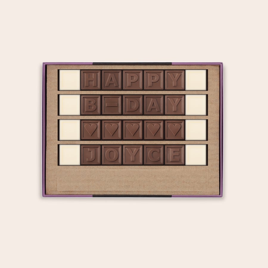 Chocotelegram Persoonlijk chocotelegram met "HAPPY B-DAY JOYCE" en hartjes van melkchocolade en witte spaties in luxe doos.