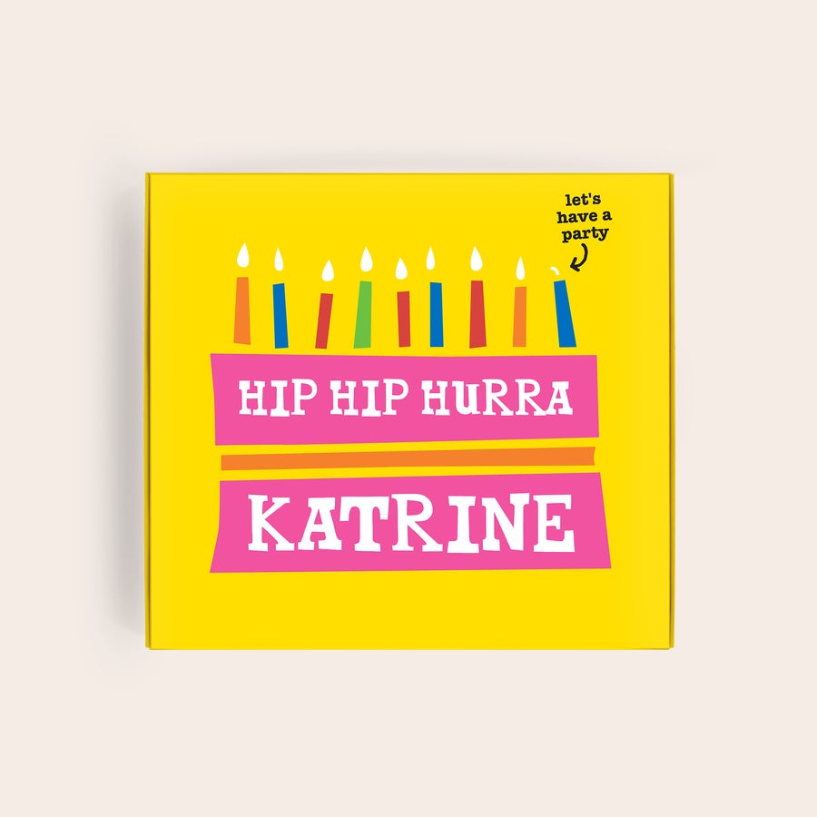 Tony's Chocolonely Chokolade Gaveæske med billede og navn Tony's Chocolonely Hasselnød gaveæske i gult design med kage og farvede lys, printet med Hip Hip Hurra og navnet Katrine.