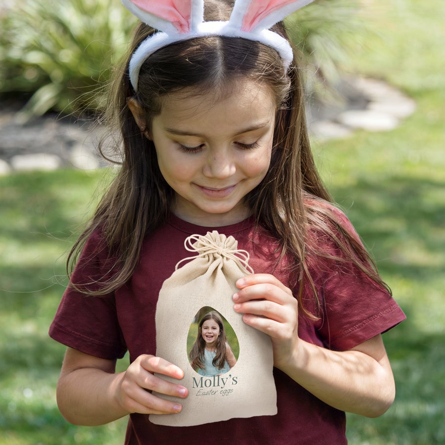 Bolsa de regalo con cordón - Pascua Niña con orejas de conejo sosteniendo una bolsa de Pascua personalizada con su foto en forma de huevo y el texto Molly's Easter eggs.