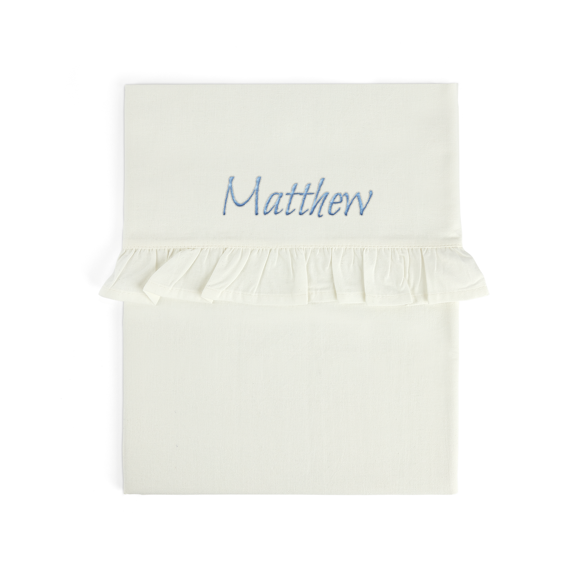 Sábana de moisés blanca con volante, bordada con el nombre "Matthew" en azul.