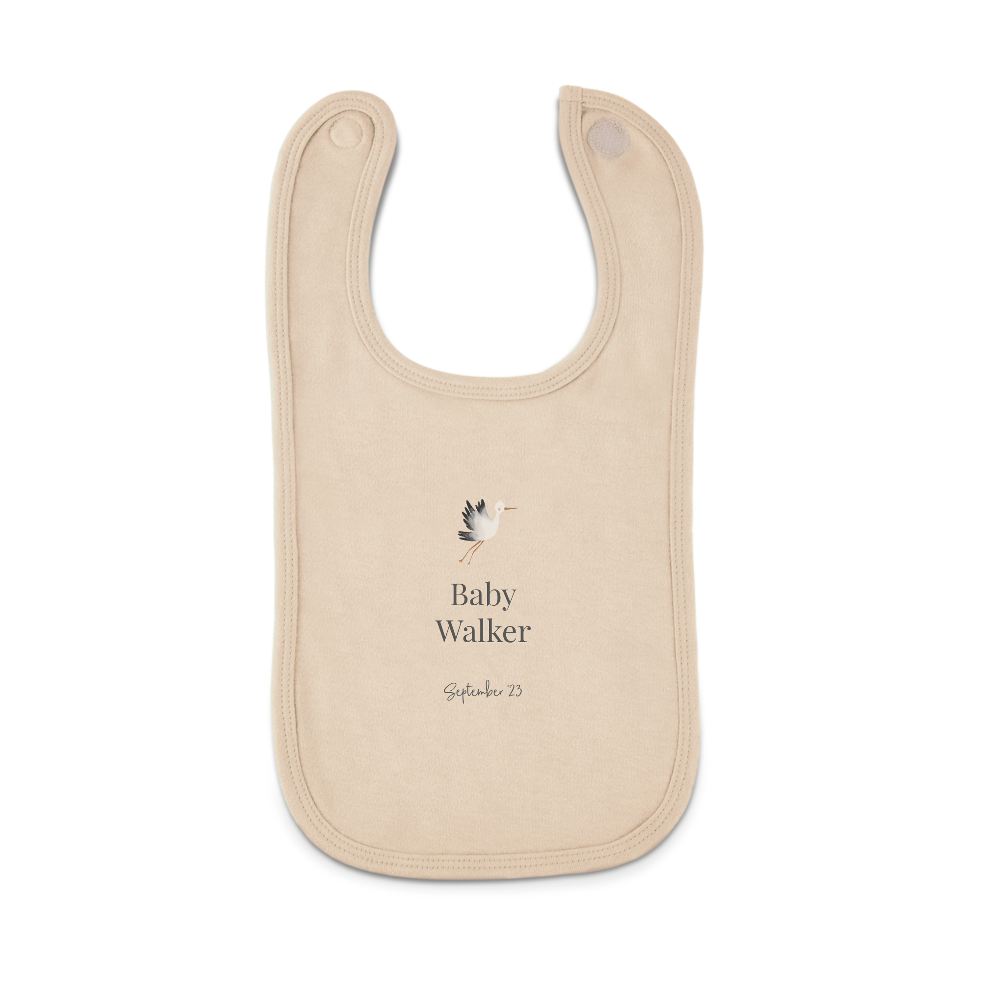 Personaliziran oprsnik bež barve z natisnjenim dizajnom štorklje, imenom Baby Walker in datumom September 23.