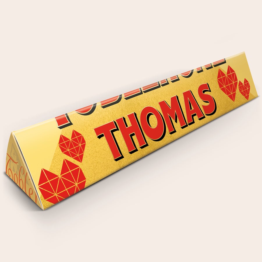 Toblerone XXL bedrukken Gepersonaliseerde XXL Toblerone reep met naam Thomas en rode hartjes, bedrukt op de wikkel.