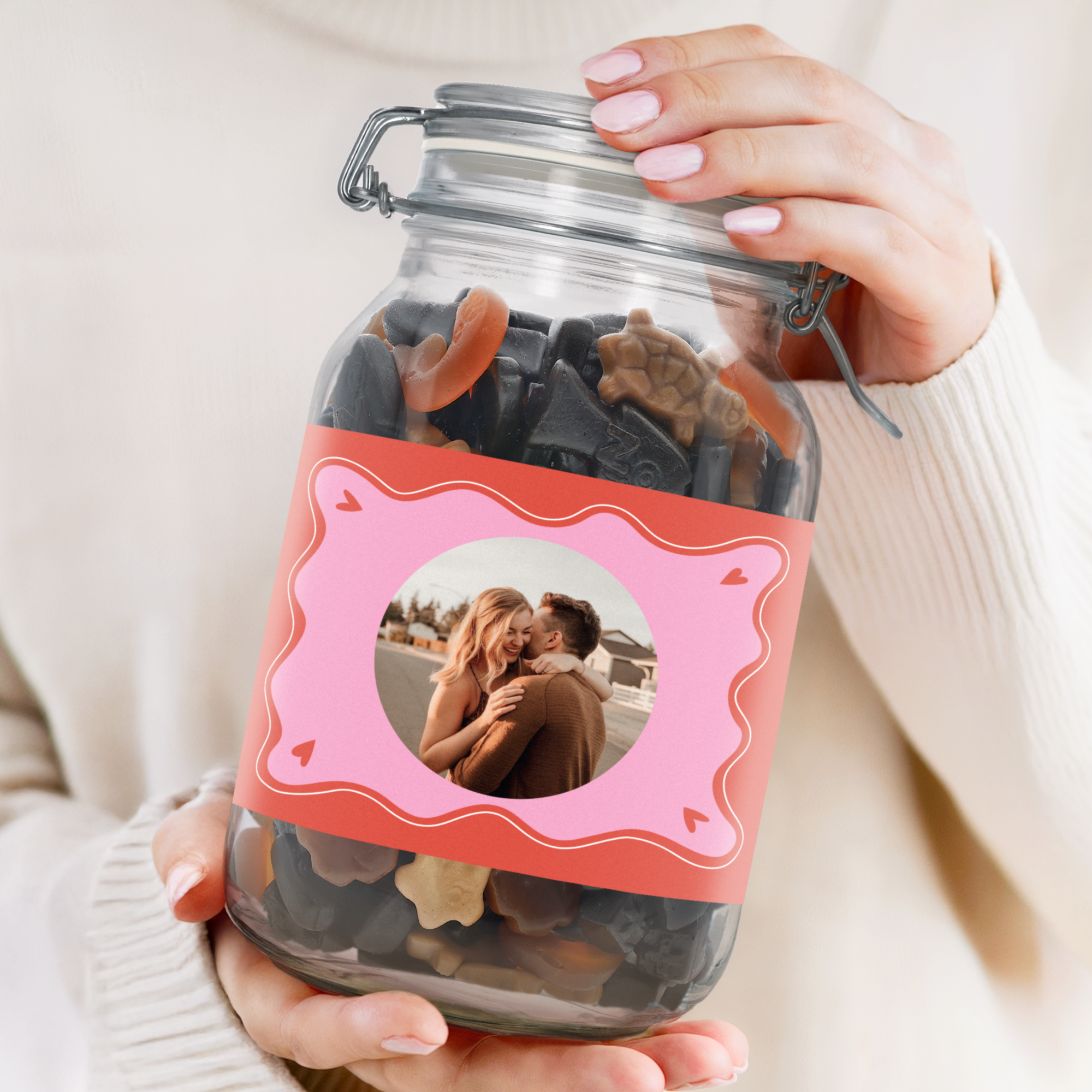 Personalisiertes Bonbonglas mit Lakritzmischung, bedruckt mit einem Pärchenfoto auf rosa Etikett