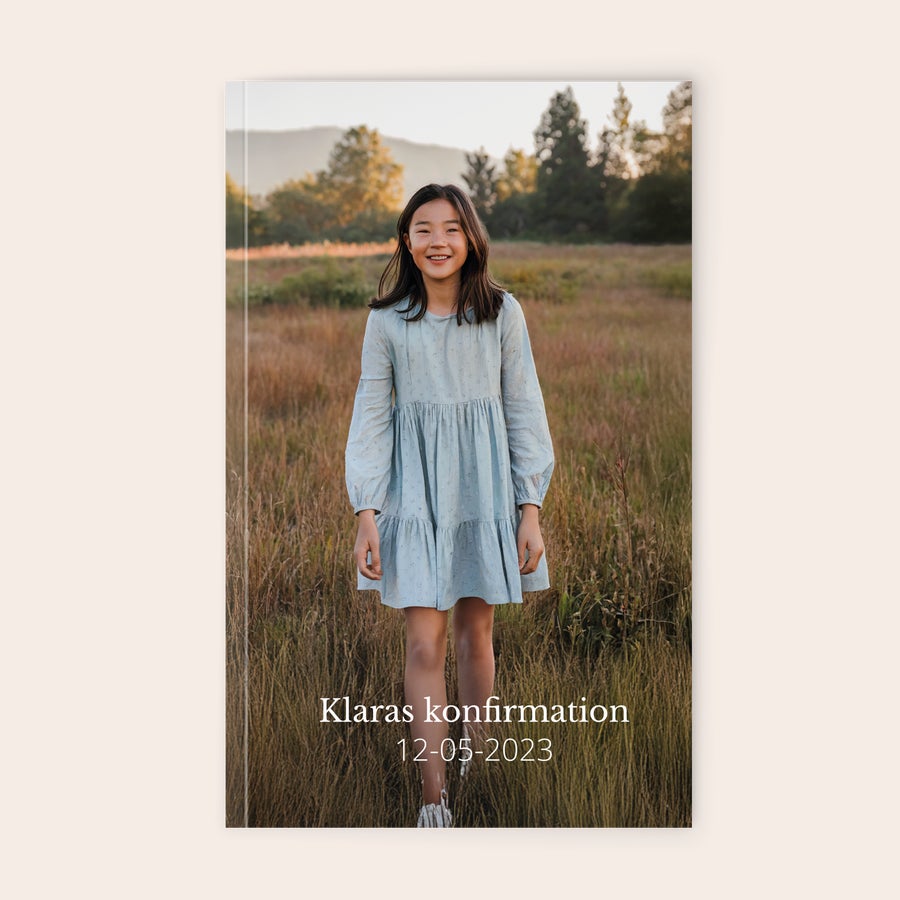 Trykt notesbog Personlig notesbog med et foto af en pige i en mark og teksten Klaras konfirmation 12-05-2023. Tilpas en notesbog med de smukkeste billeder i et køligt design!