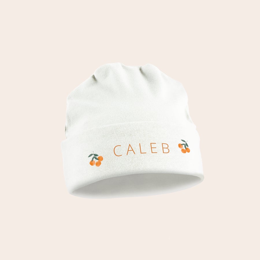 Baby lue Hvit baby lue med trykt navn CALEB og kirsebærdesign.