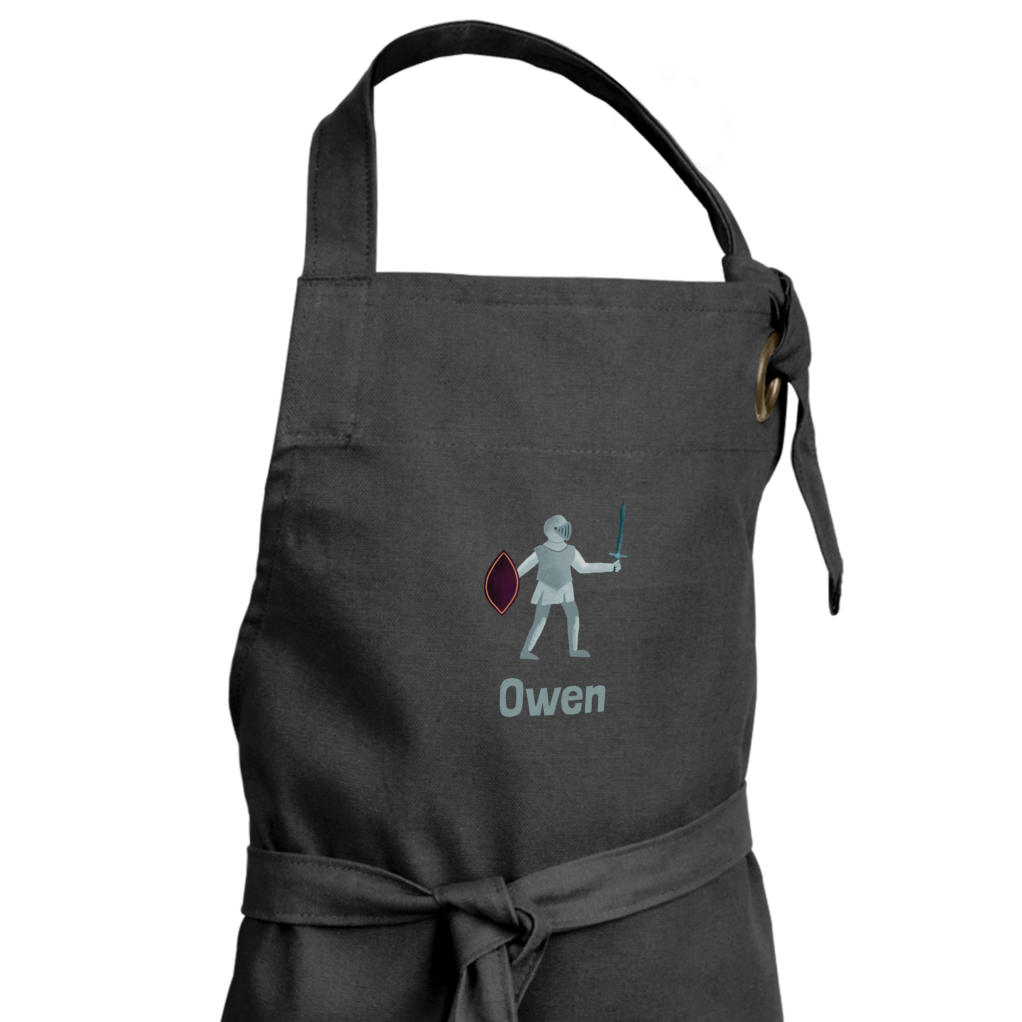 Grembiule nero per bambini personalizzato con il nome Owen e un disegno di un cavaliere con spada e scudo stampati.