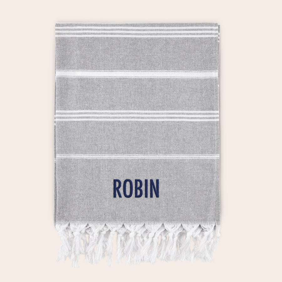Asciugamano Hammam con nome Telo hamman in cotone grigio con strisce bianche, ricamato con il nome Robin in blu. Preparati per l'estate con un telo hamman in cotone personalizzato.